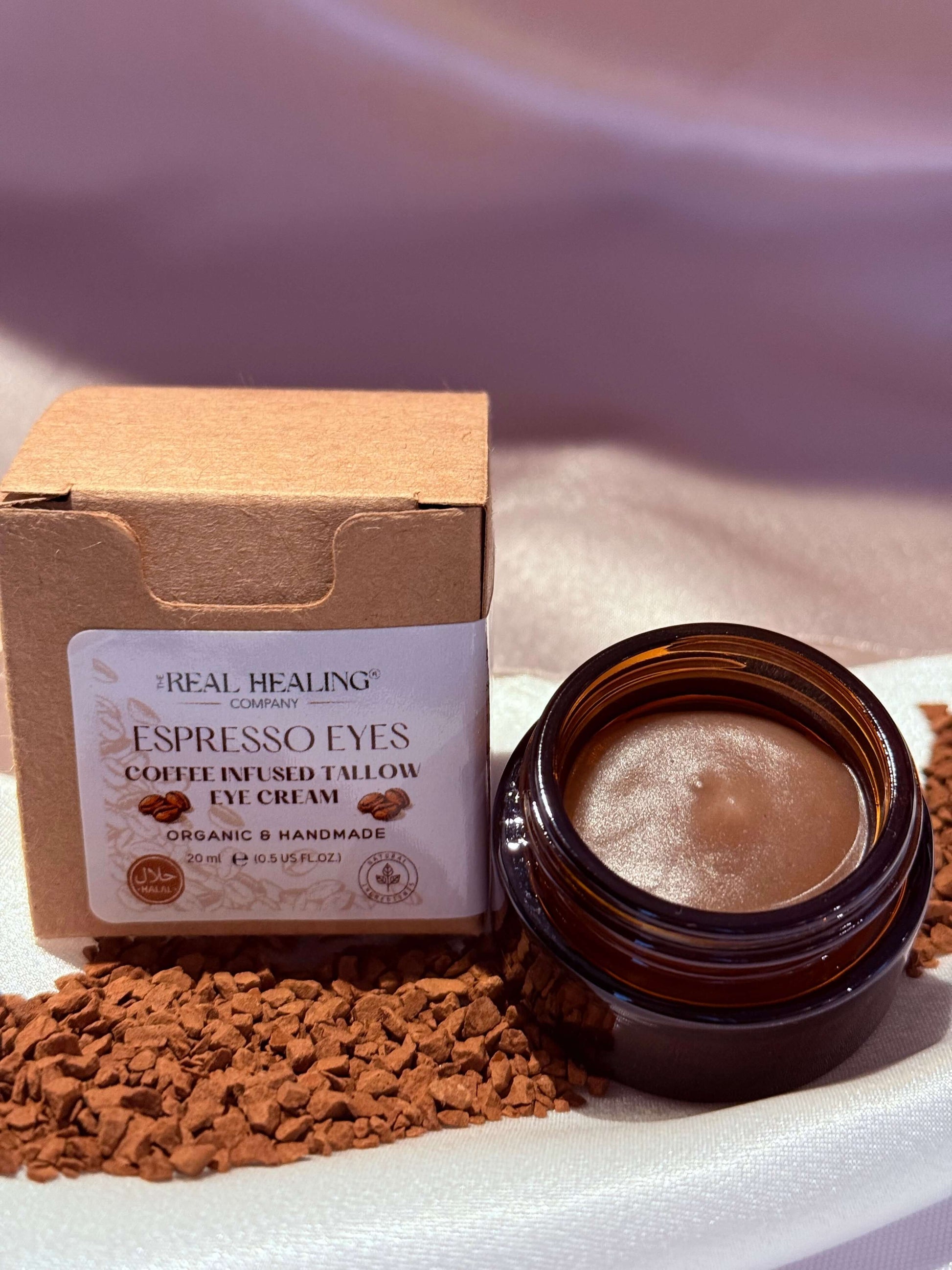 Espresso Eyes coffee-infused tallow eye cream in a jar beside coffee grounds, promoting hydration and rejuvenation.